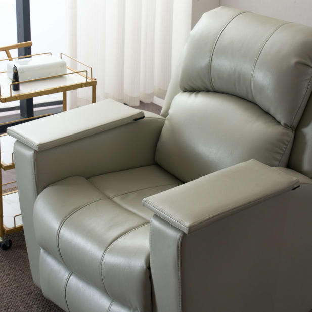 Light grey electric reclining nail spa chair with flip-up armrests, upright position in modern salon Light grey electric reclining nail spa chair with flip-up armrests, upright position in modern salon